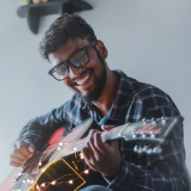 Man playing guitar with a smile