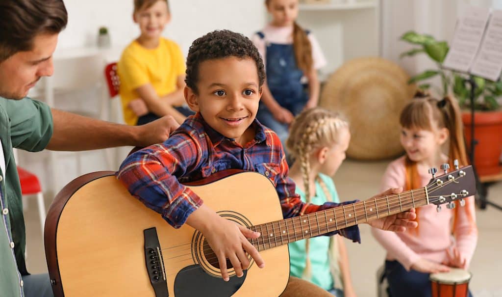 Teacher giving music lessons at school - try before you buy an instrument with Dietze Music.