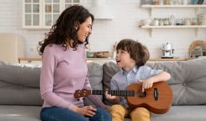 Mom and son trying out their guitar rental before buying.
